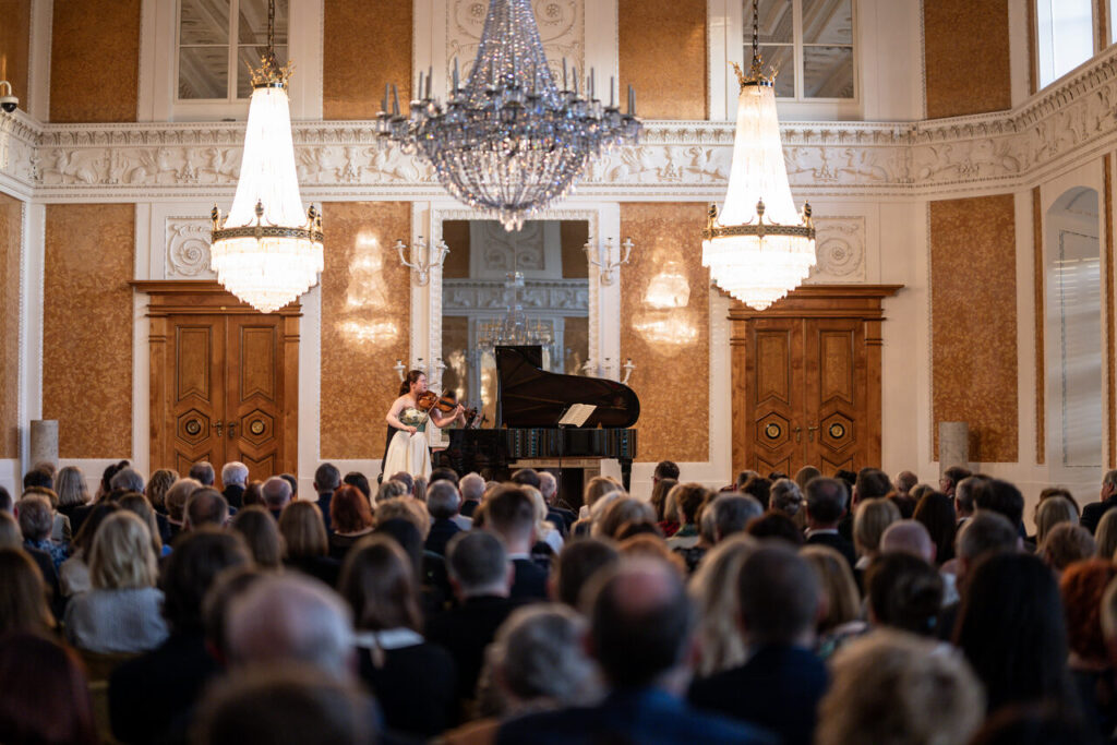 Hina Maeda (skrzypce) i Michał Francuz (fortepian) oraz publiczność w Sali Balowej Muzeum Zamku w Łańcucie